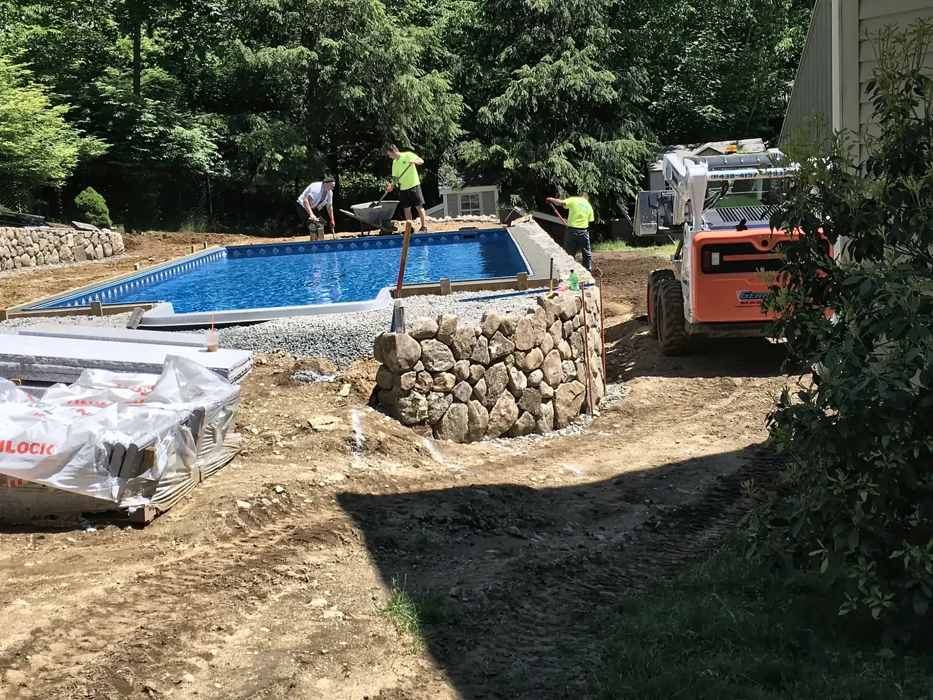 Round fieldstone wall rising beside a pool in North Reading, MA