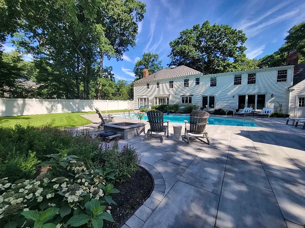 Fire pit seating on a pool deck beside the garden in Lynnfield, MA