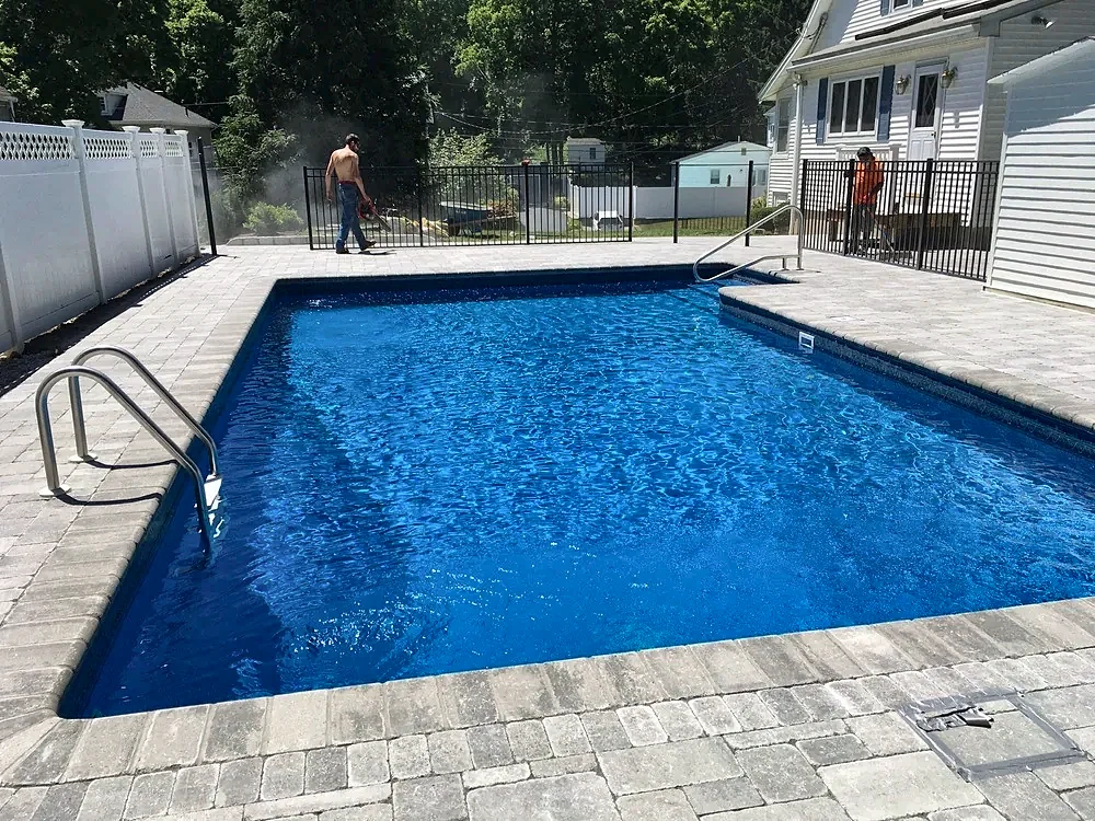 Paver pool patio with a pool fence by Gerrior Masonry