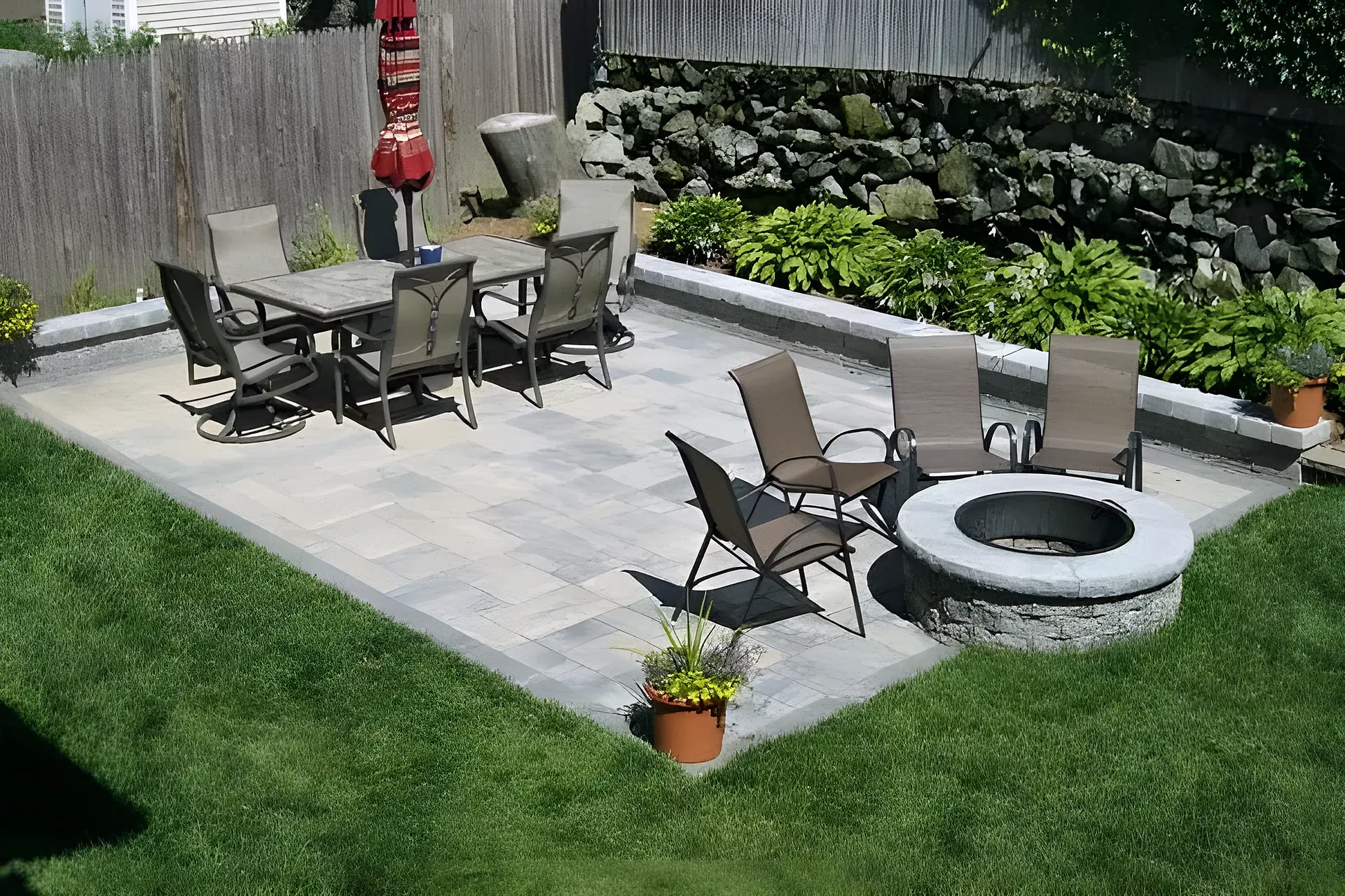 Round fire pit patio in the backyard by Gerrior Masonry