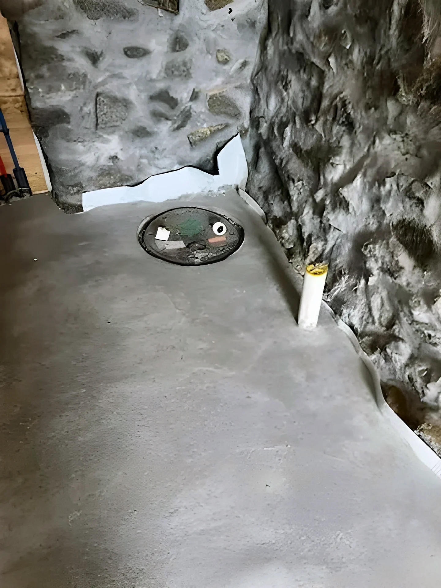 Fieldstone foundation wall and new concrete floor in a basement crawl space