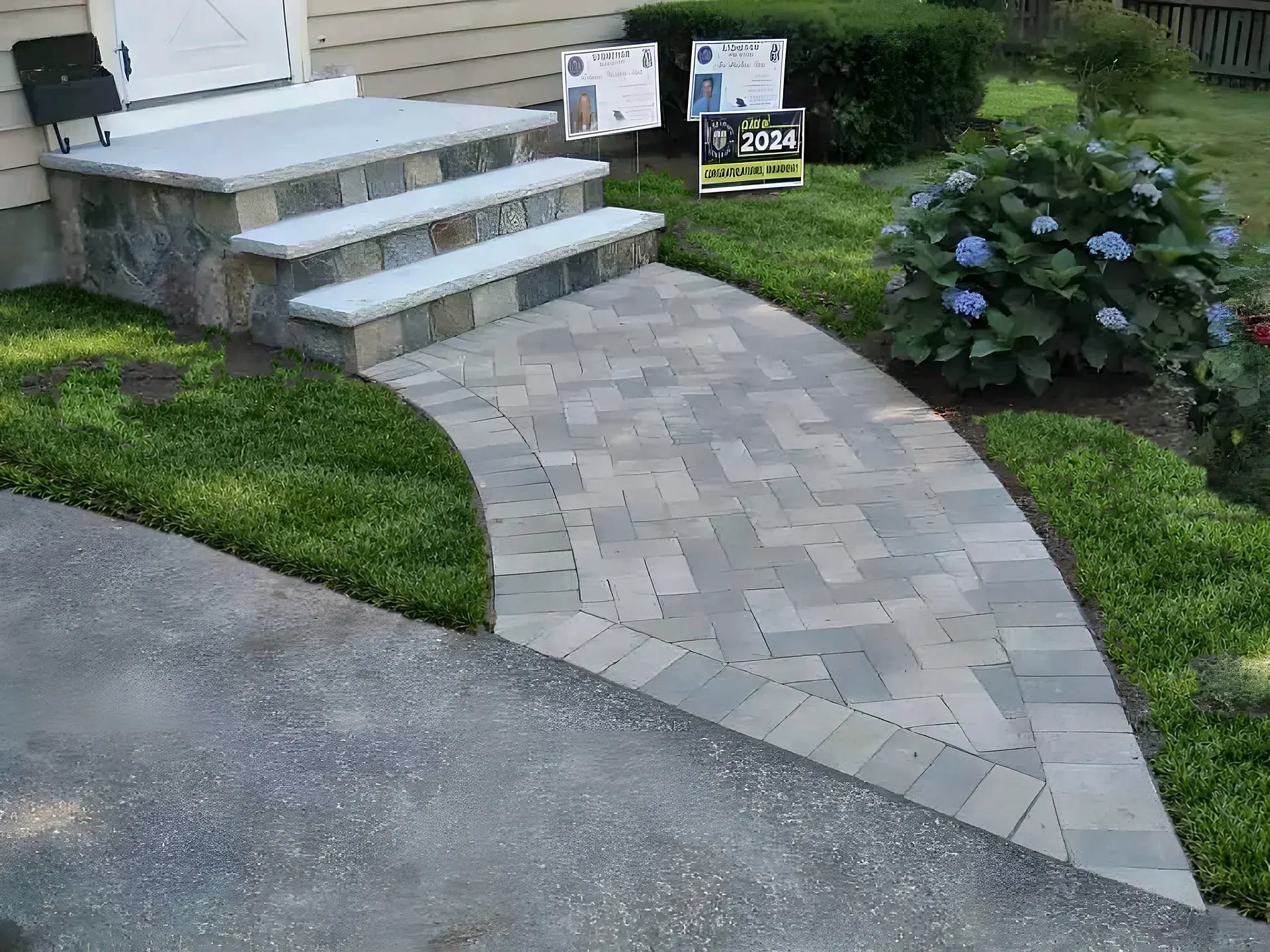Curved gray paver walkway leading to granite and stone front steps