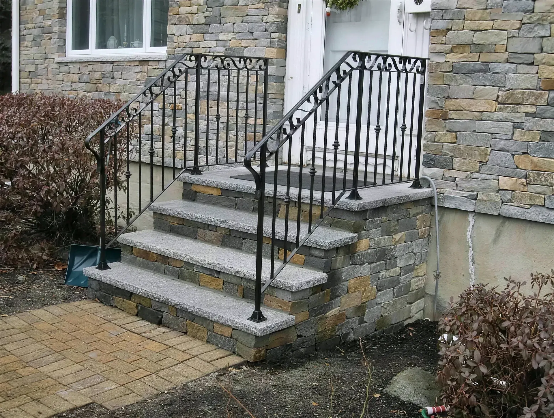 Stone entry steps and stone veneer Gerrior built along a home's foundation
